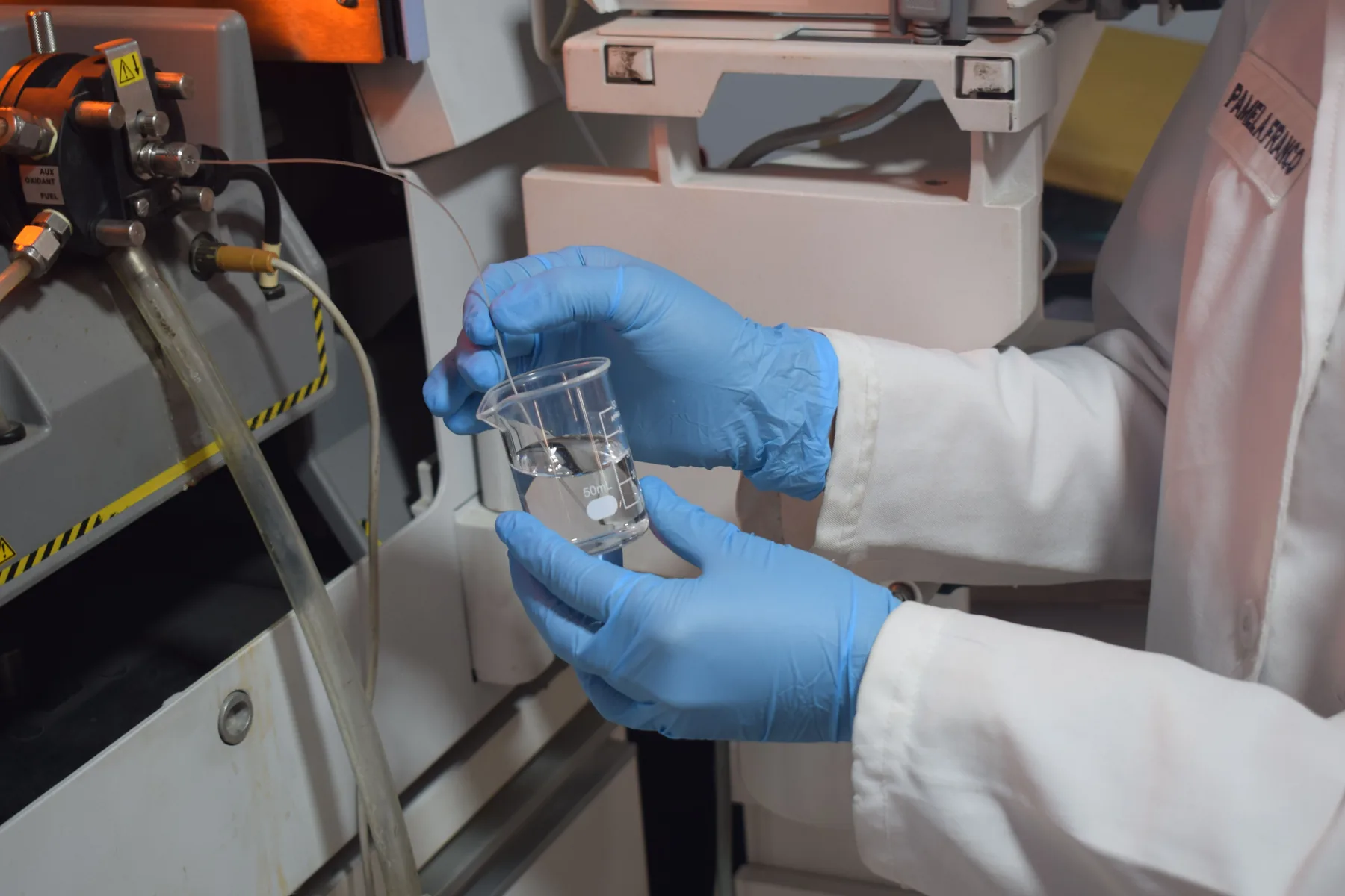 Scientist handling a clear liquid sample in a laboratory